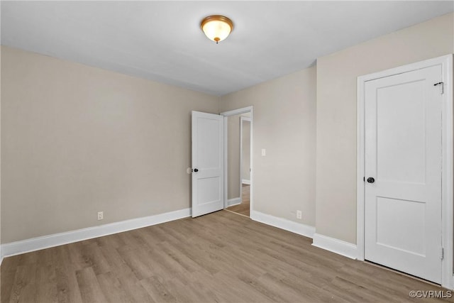 unfurnished room featuring baseboards and light wood-style flooring