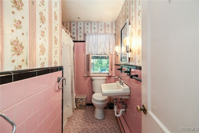 full bathroom with tile walls, a shower, a wainscoted wall, toilet, and wallpapered walls