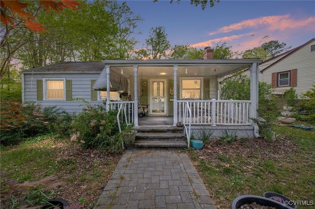 bungalow-style home with a porch and a chimney