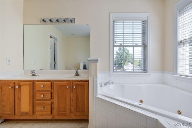 full bathroom with double vanity, a whirlpool tub, a sink, and visible vents