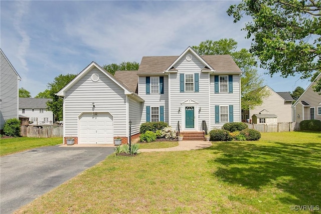colonial home featuring fence, an attached garage, a front lawn, and aphalt driveway