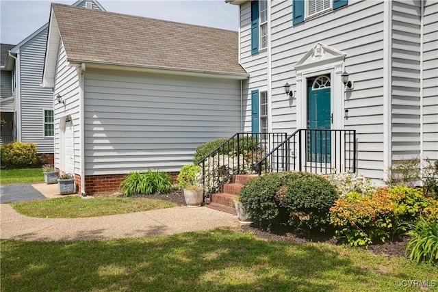 entrance to property with roof with shingles