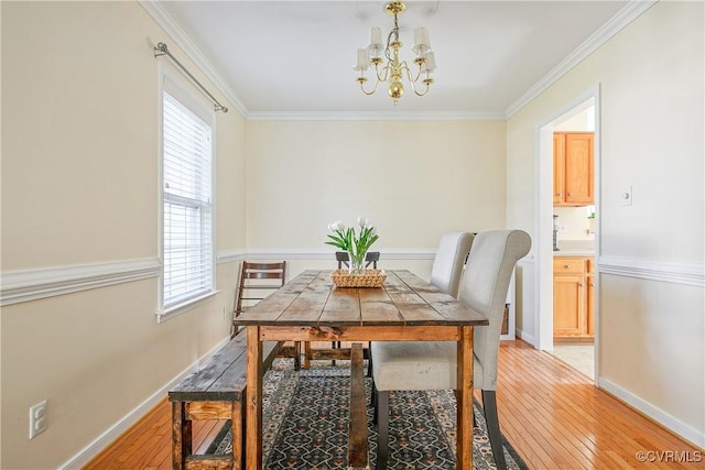 dining space with crown molding, a notable chandelier, a healthy amount of sunlight, and light wood-type flooring