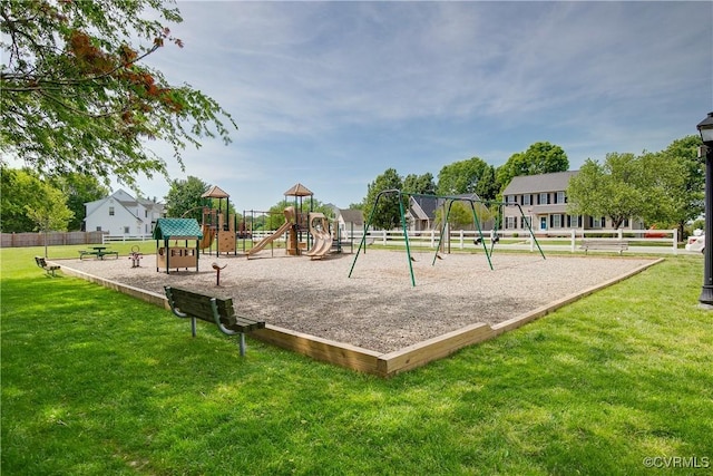 community play area featuring a lawn and fence