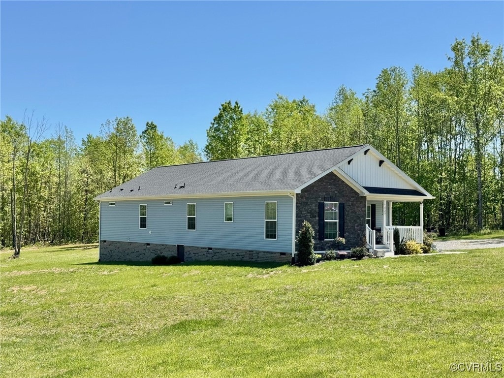 view of front of property with covered porch, a front yard, and crawl space