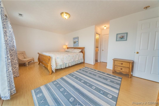 2000 Jenkins Neck Rd, Hayes, VA 23072 - bedroom featuring visible vents, ensuite bathroom, and wood finished floors