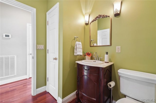 20145 Hunnicut Rd, Dinwiddie, VA 23803 - half bathroom with visible vents, vanity, wood finished floors, toilet, and baseboards