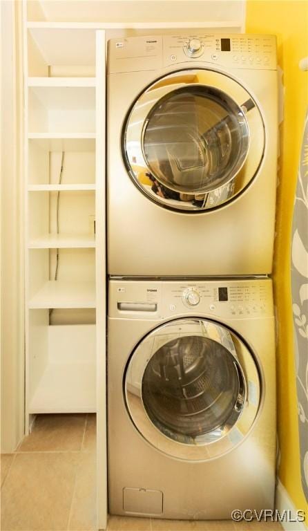 laundry area with tile patterned floors, stacked washer and clothes dryer, and laundry area