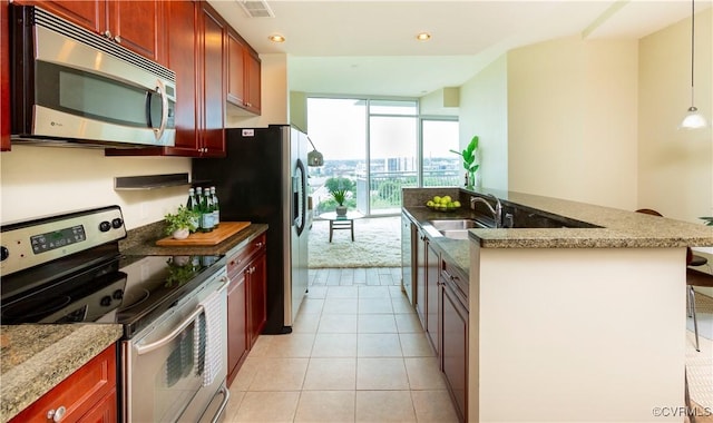 kitchen featuring dark brown cabinets, appliances with stainless steel finishes, a wall of windows, a sink, and visible vents