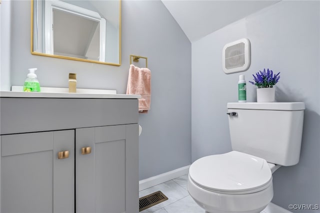 bathroom featuring visible vents, vanity, marble finish floor, lofted ceiling, and baseboards