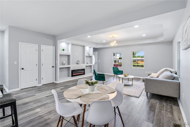 dining area featuring recessed lighting, baseboards, a glass covered fireplace, and wood finished floors