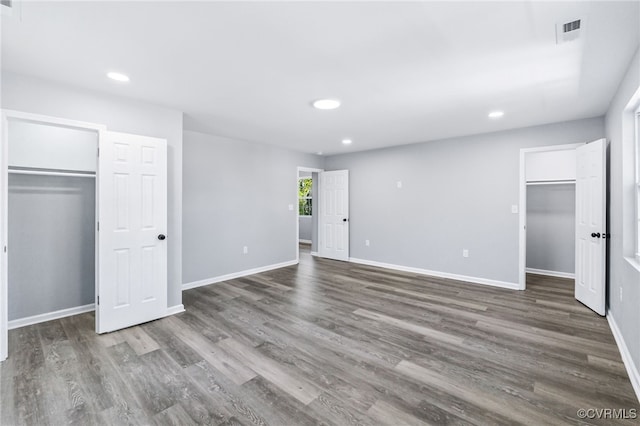 unfurnished bedroom featuring recessed lighting, visible vents, a walk in closet, and a closet