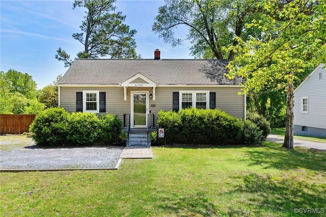 view of front facade featuring fence, a chimney, and a front lawn