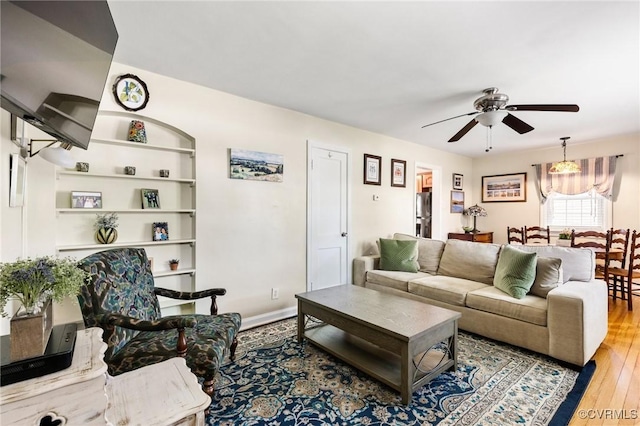 living room with a ceiling fan and wood finished floors