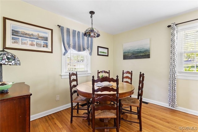 dining area with baseboards and light wood-type flooring