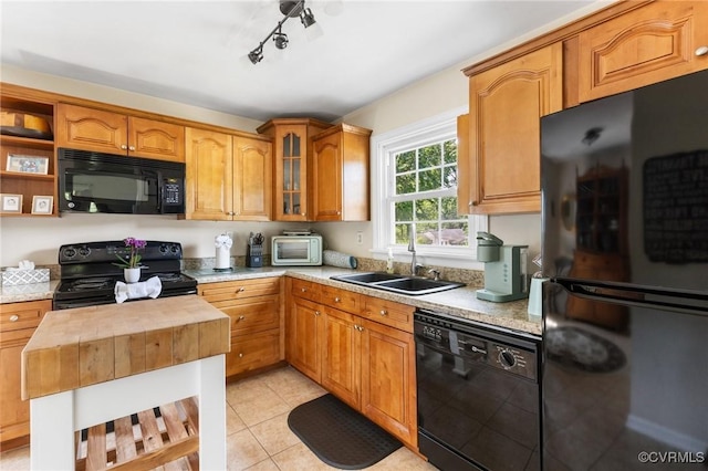 kitchen with open shelves, a sink, light tile patterned floors, glass insert cabinets, and black appliances