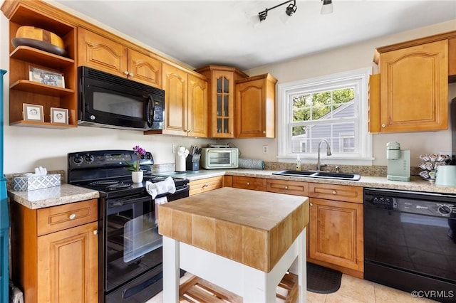 kitchen featuring light tile patterned flooring, a sink, wood counters, glass insert cabinets, and black appliances