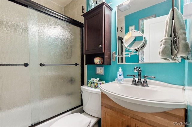 bathroom featuring toilet, enclosed tub / shower combo, and vanity