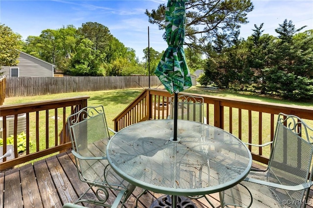 wooden terrace featuring a fenced backyard, outdoor dining area, and a yard
