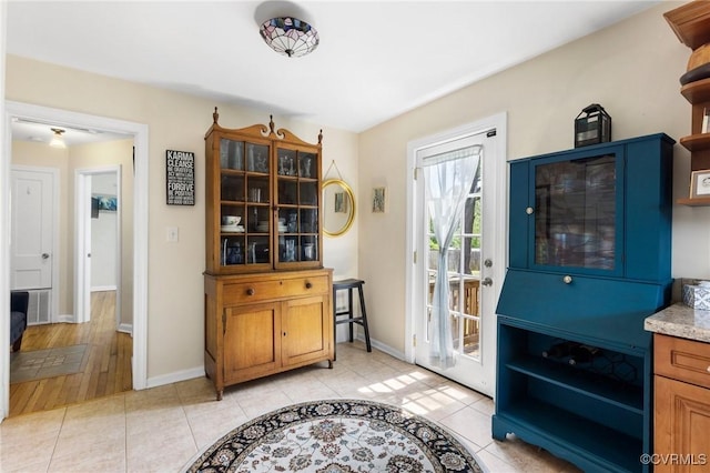 interior space with baseboards and light tile patterned floors