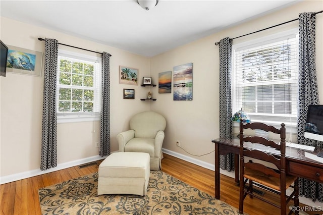 sitting room with baseboards and wood finished floors