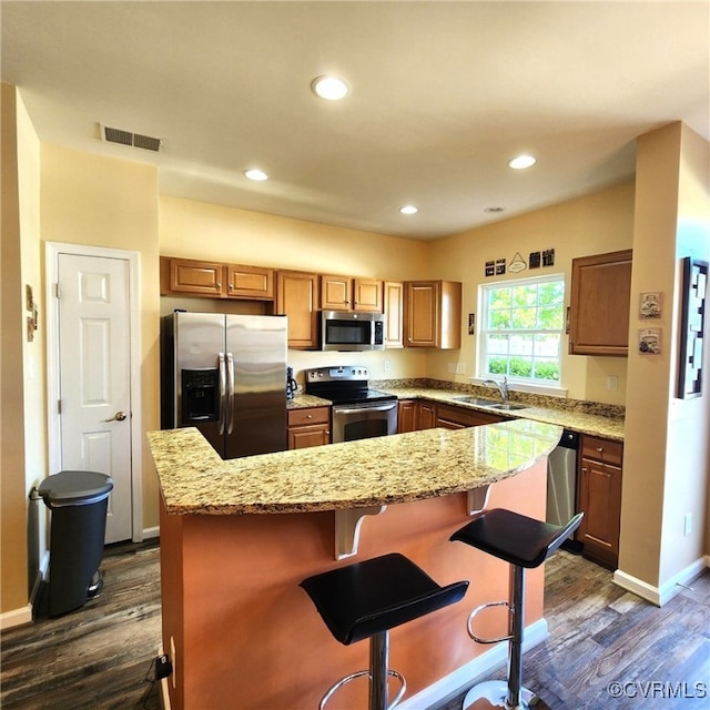 8133 Belton Cir, Mechanicsville, VA 23116 - kitchen with appliances with stainless steel finishes, dark wood finished floors, light stone counters, a breakfast bar, and recessed lighting