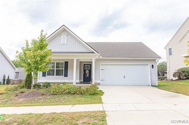 view of front of house with an attached garage, board and batten siding, a front yard, concrete driveway, and covered porch