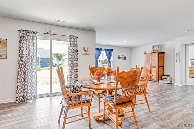 dining area with baseboards, visible vents, and light wood-style flooring