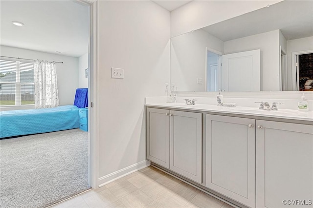 full bathroom with double vanity, baseboards, a sink, and tile patterned floors