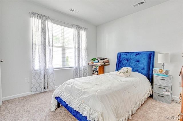 bedroom with baseboards, visible vents, and carpet