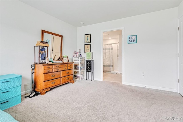 bedroom with carpet flooring, baseboards, and ensuite bath