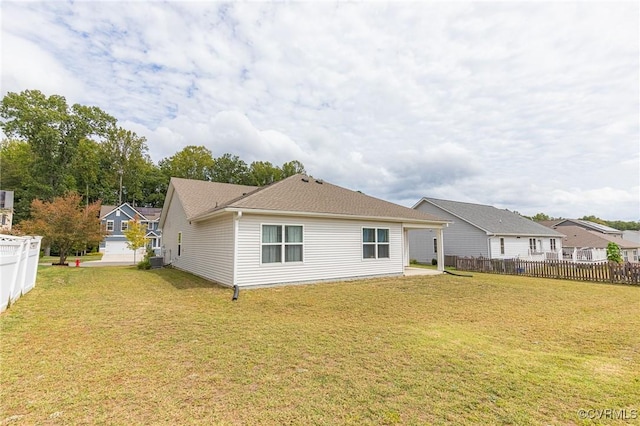 rear view of house with fence, a lawn, and cooling unit