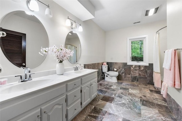 3640 Michaux Mill Dr, Powhatan, VA 23139 - bathroom with tile walls, double vanity, wainscoting, a shower with shower curtain, and marble tiled floors