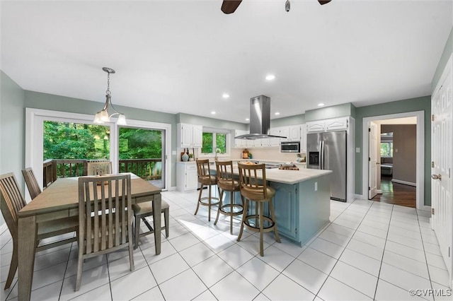 3640 Michaux Mill Dr, Powhatan, VA 23139 - kitchen with appliances with stainless steel finishes, island exhaust hood, light countertops, white cabinetry, and plenty of natural light