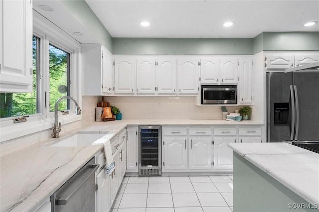3640 Michaux Mill Dr, Powhatan, VA 23139 - kitchen with wine cooler, appliances with stainless steel finishes, light tile patterned flooring, light stone countertops, and decorative backsplash