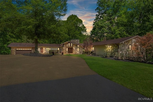 3640 Michaux Mill Dr, Powhatan, VA 23139 - view of front of home with stone siding, driveway, an attached garage, a front yard, and a chimney