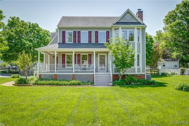 victorian house featuring covered porch, a chimney, roof with shingles, and a front lawn