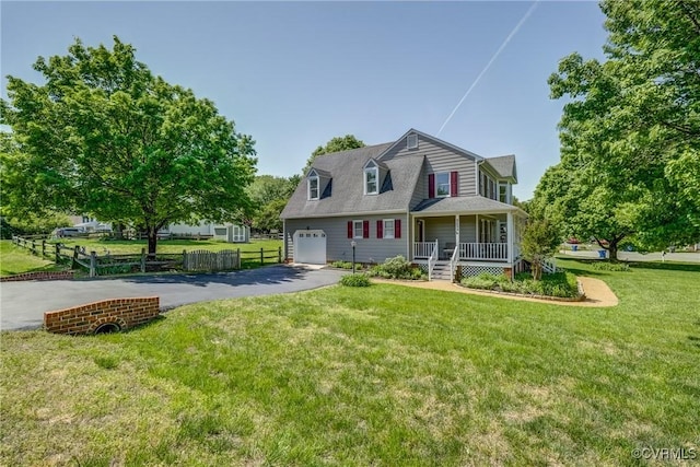 view of front of house featuring covered porch, driveway, a garage, fence, and a front lawn