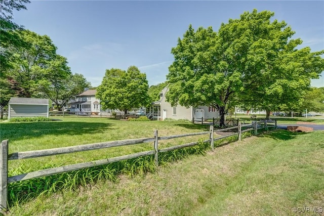 view of yard with an outdoor structure, fence, and a shed