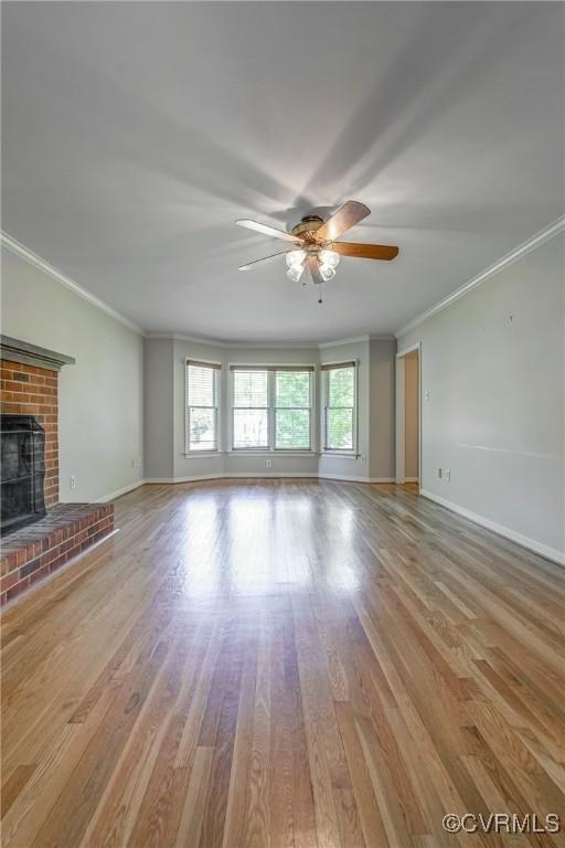 unfurnished living room featuring a ceiling fan, baseboards, and ornamental molding