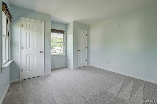unfurnished bedroom with carpet floors and baseboards