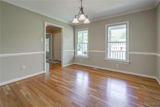 spare room with baseboards, light wood finished floors, a chandelier, and visible vents