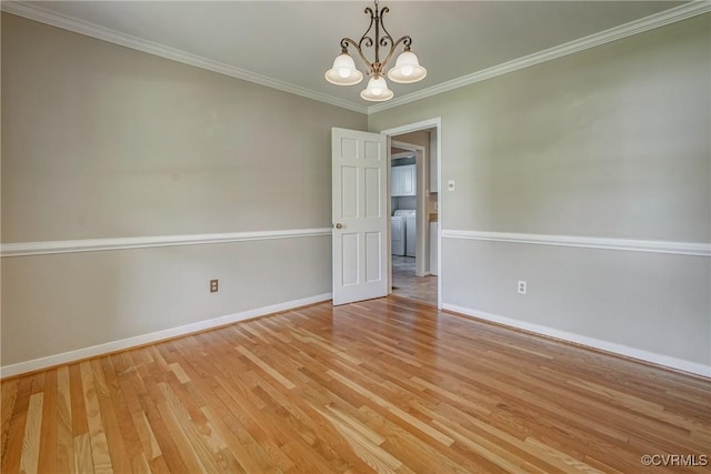 empty room with baseboards, light wood finished floors, independent washer and dryer, and a notable chandelier
