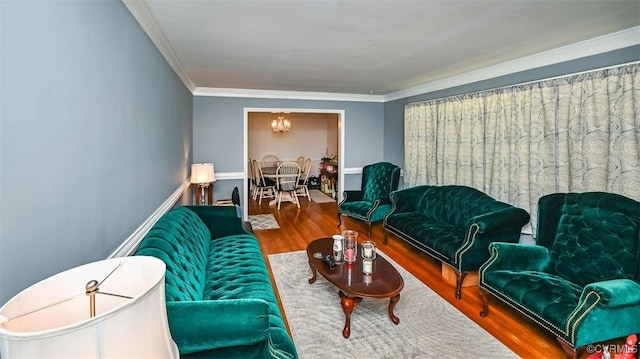 living area featuring ornamental molding, wood finished floors, and a chandelier