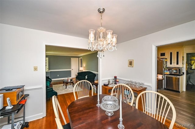 dining area featuring an inviting chandelier and wood finished floors