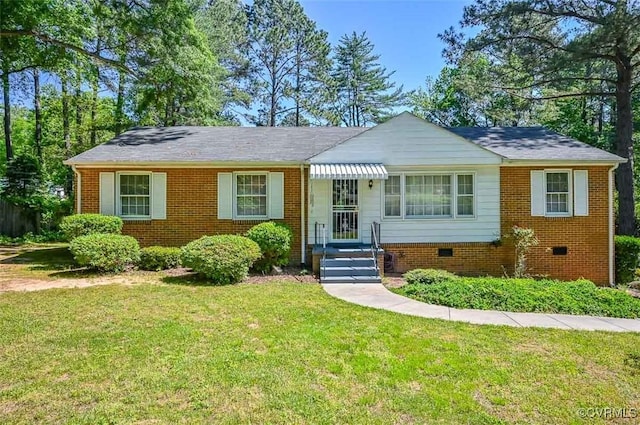 view of front of property featuring brick siding, crawl space, and a front yard