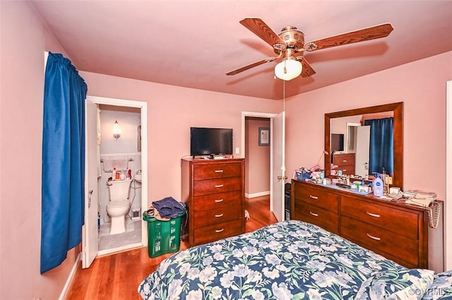 bedroom with baseboards, a ceiling fan, connected bathroom, and wood finished floors