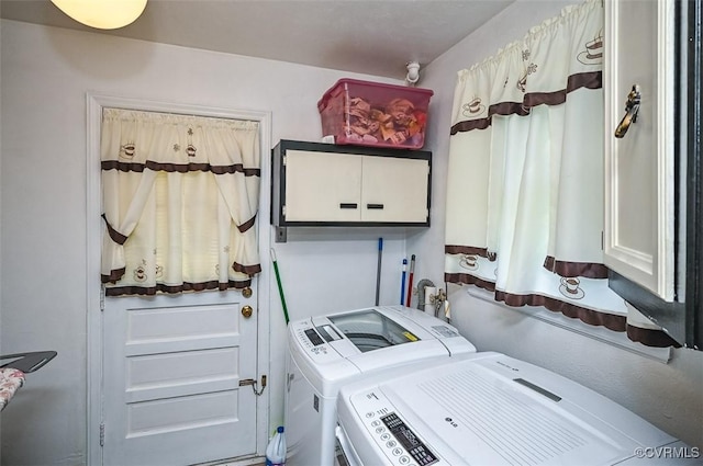 laundry room featuring separate washer and dryer and cabinet space