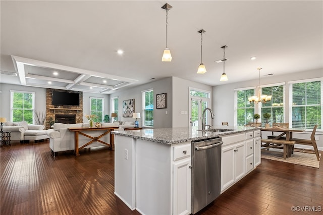 kitchen with a sink, a fireplace, dark wood-style floors, and dishwasher