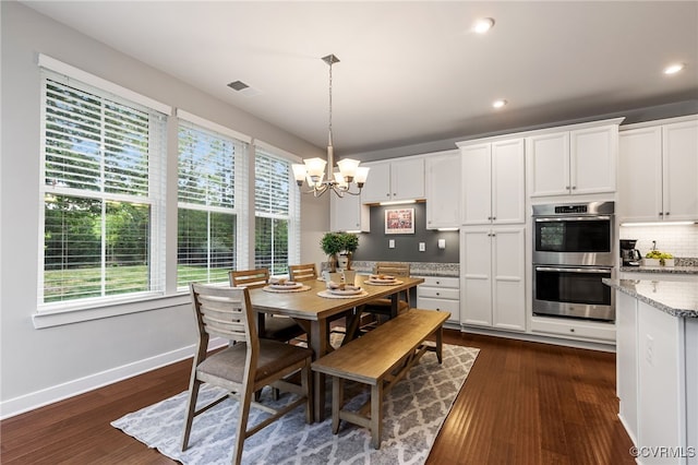 dining space featuring dark wood-style flooring, baseboards, a chandelier, and visible vents